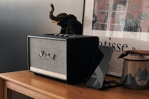 gray Marshall speaker on wooden surface