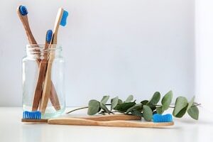 blue and white toothbrush in clear glass jar