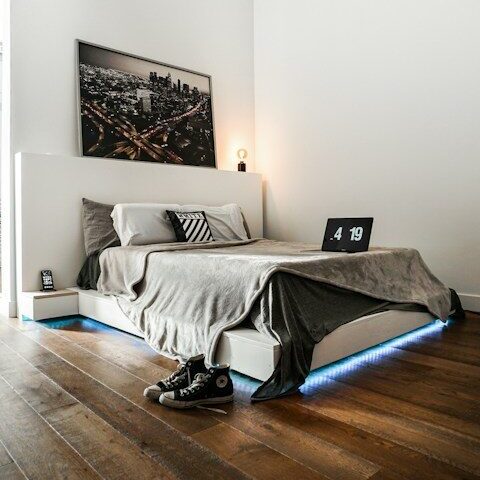 black laptop computer on white bed
